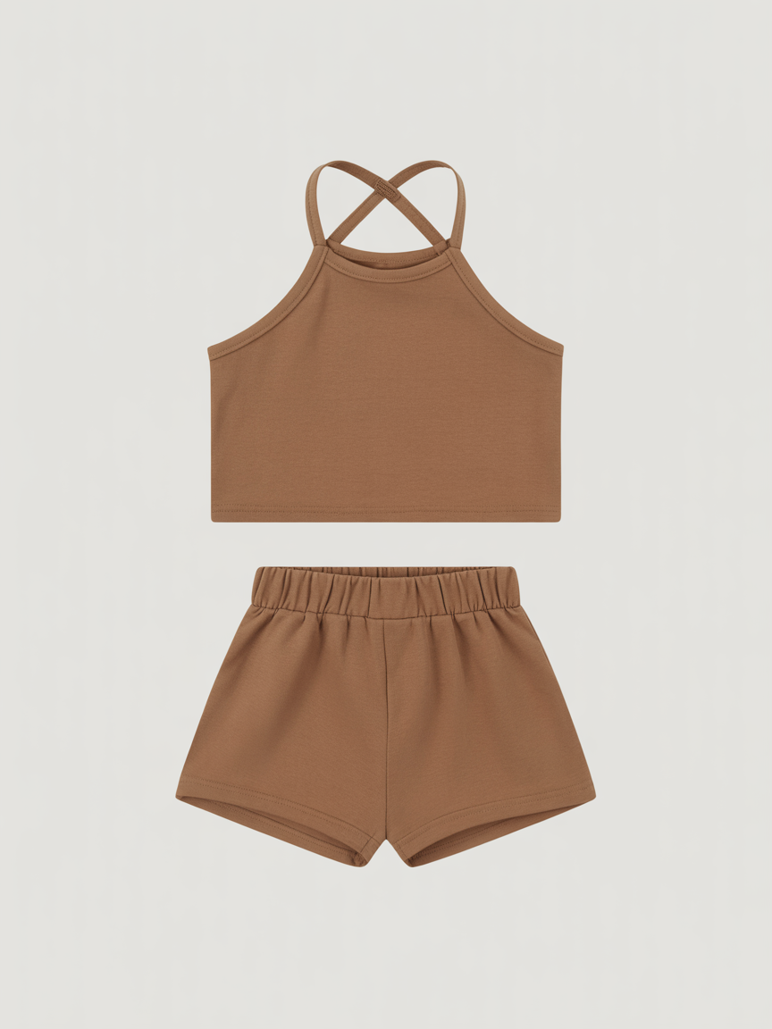 Displayed in a clean studio setting, this custom children's outfit showcases minimalist design and thoughtful craftsmanship. The set includes a sleeveless halter-style top and high-waisted shorts in a warm brown tone, made from soft, breathable fabric. Developed from scratch in Portugal, each piece reflects high-quality local production—combining comfort, durability, and timeless style for everyday wear.