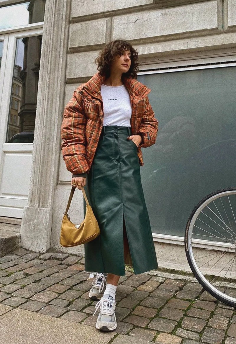 The Fall Trend Looks You Will Want To Show Off On Instagram. Green leather skirt on a casual look, with a t-shirt and orange coat.