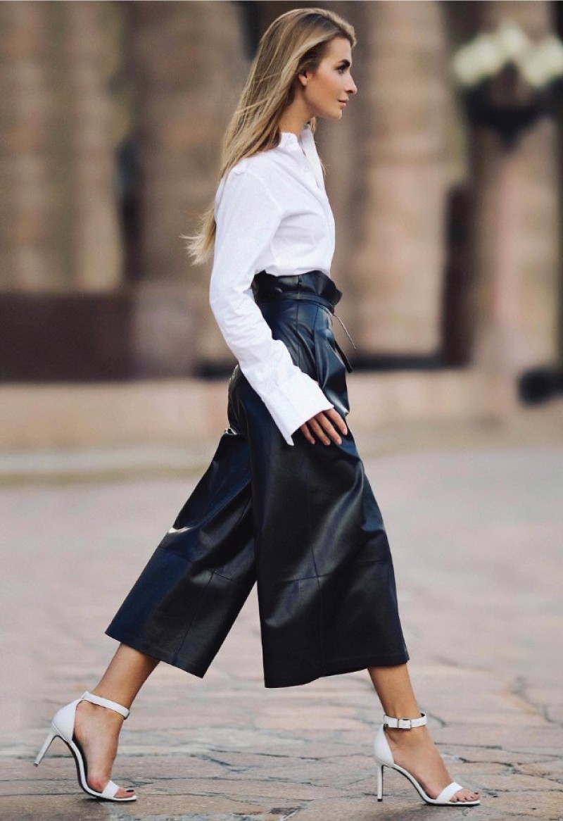 The Fall Trend Looks You Will Want To Show Off On Instagram. Long leather shorts in black, with a white shirt and white heels.