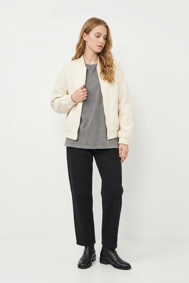 Mannequin en blouson bomber écru, t-shirt gris chiné et jean noir droit.