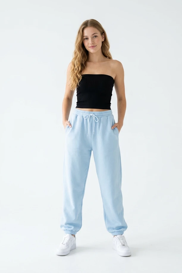 Mannequin portant un bustier tube noir et un pantalon de jogging bleu pastel.