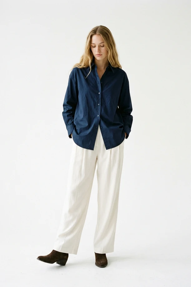 Mannequin en chemise oversize popeline bleu marine et pantalon fluide blanc.