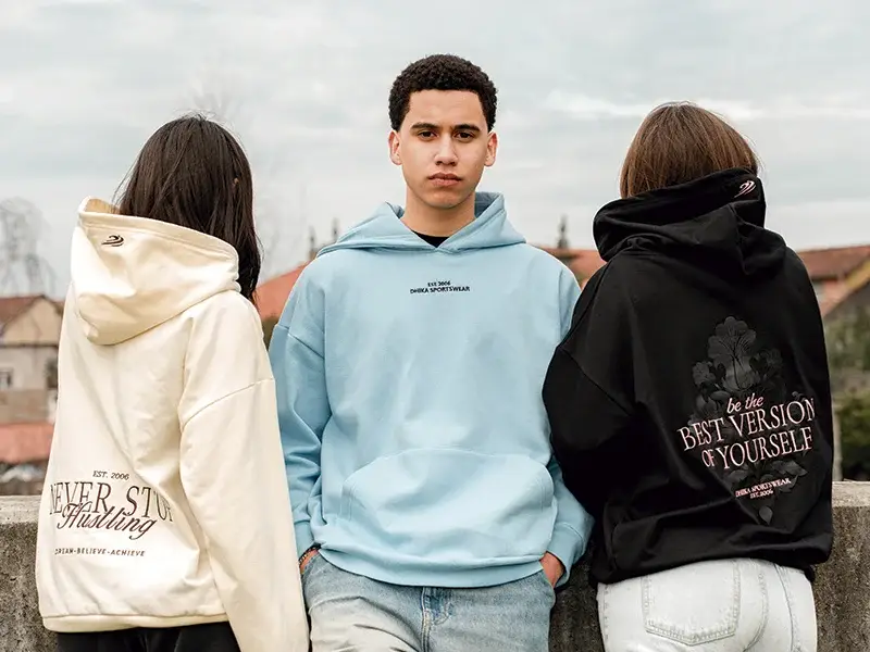 Group of young adults modeling hoodies from a Portugal sportswear manufacturer, featuring motivational quotes and urban streetwear designs.