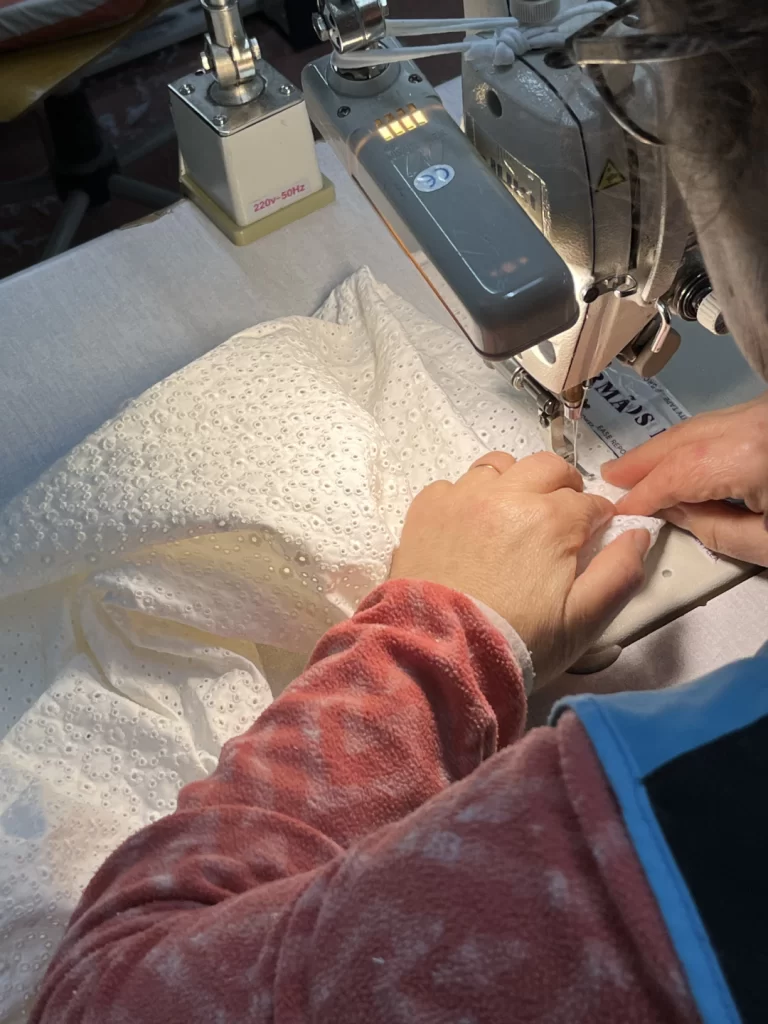 A seamstress hand-finishing a luxury garment in a Portuguese factory