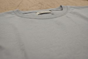 A premium grey t-shirt made with high-quality Portuguese fabric, highlighting the expert construction and "Made in Portugal" label.